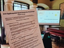 Zdjęcie z sali konferencyjnej, w tle widoczny rzutnik z wyświetloną prezentacja nt. Polskiej Biblioteki Muzycznej. Na pierwszym planie kartka z agendą spotkania.